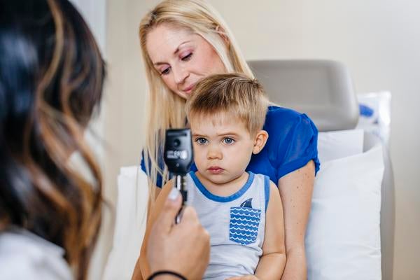 Doctor with young patient and mother